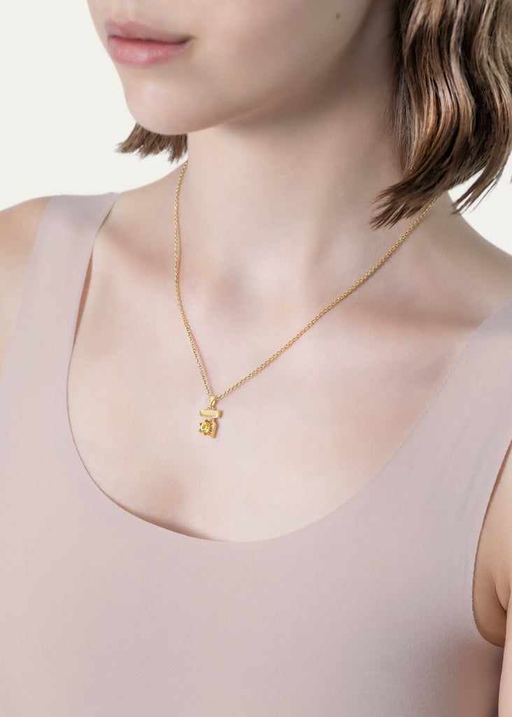 Model wearing 18K Gold Hebrew DALET Necklace with Yellow Sapphire in Yellow Gold by Procaccia Jewelry