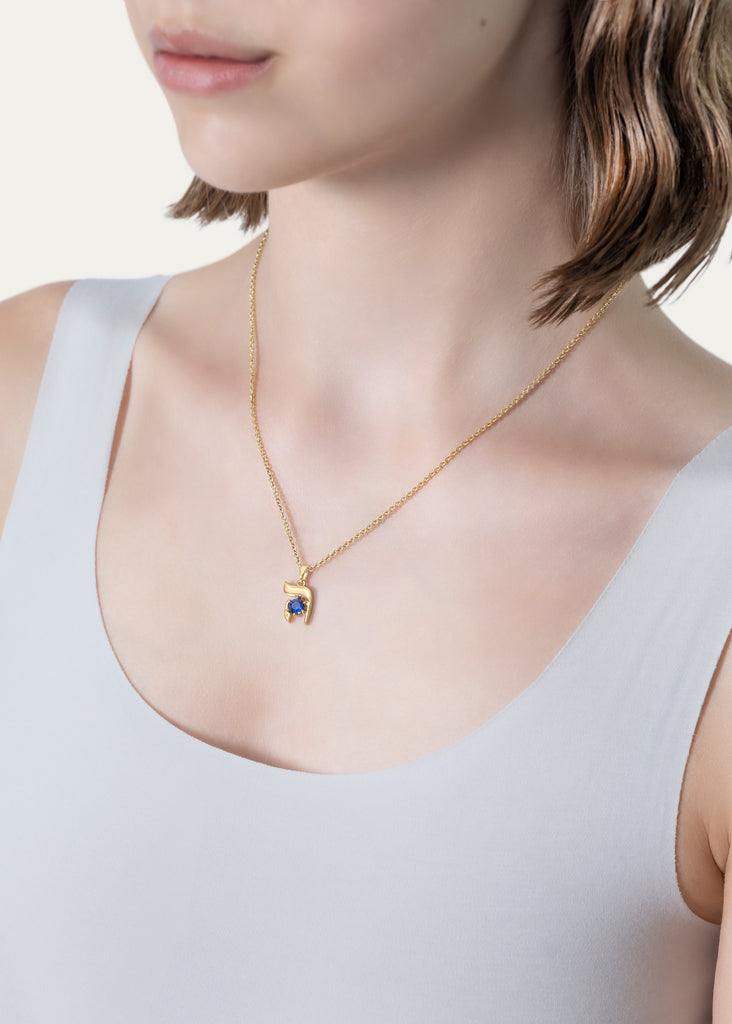 Model wearing 18K solid yellow gold  Hebrew Letter Initial HEI pendant necklace with blue sapphire